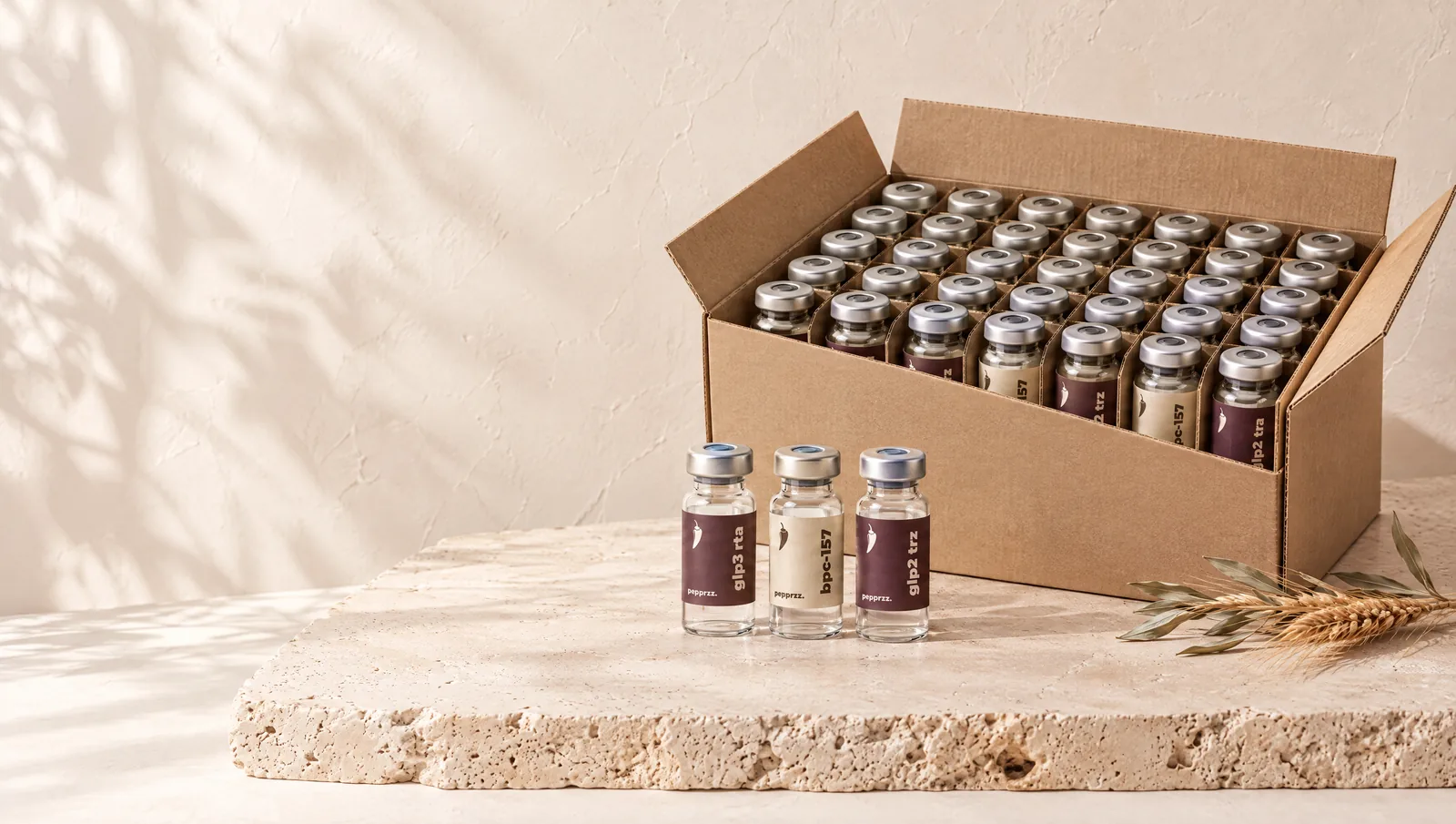 An open carton of pepprzz research vials on a travertine slab
